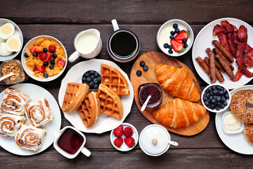Breakfast or brunch table scene. Overhead view on a dark wood background. Selection of sweet and...