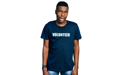 Fototapeta premium Young african american man wearing volunteer t shirt in shock face, looking skeptical and sarcastic, surprised with open mouth