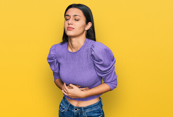 Young hispanic girl wearing casual clothes with hand on stomach because indigestion, painful illness feeling unwell. ache concept.