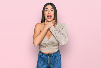 Young hispanic woman wearing casual clothes shouting and suffocate because painful strangle. health...
