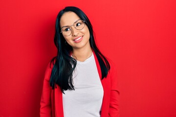 Beautiful hispanic woman with nose piercing wearing casual look and glasses looking away to side...