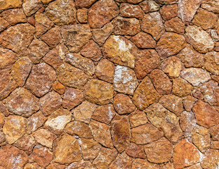 rough irregular cut brown stone wall, seamless pattern textured background