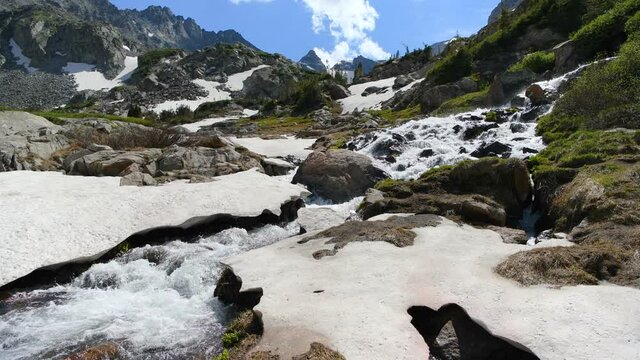 Spring Mountain Creek - Snow melting into the headwaters of South Saint Vrain Creek running down steep slopes of Indian Peaks above west end of Lake Isabelle. Indian Peaks Wilderness, Colorado, USA.
