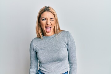 Young caucasian woman wearing casual clothes winking looking at the camera with sexy expression,...