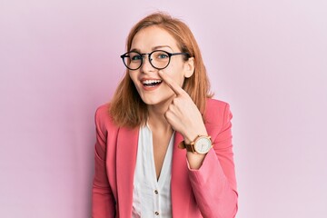 Young caucasian woman wearing business style and glasses pointing with hand finger to face and nose, smiling cheerful. beauty concept