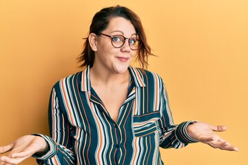 Young caucasian woman wearing casual clothes and glasses clueless and confused expression with arms...