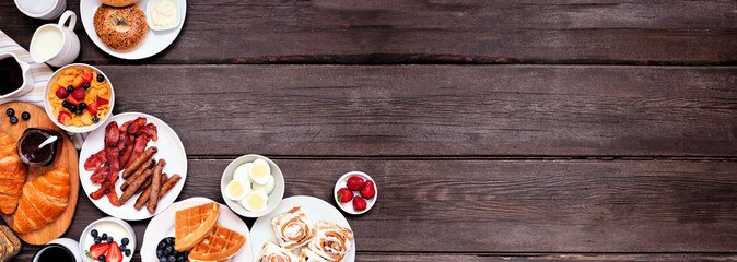 Breakfast or brunch corner border on a dark wood banner background. Above view. Different sweet and savory food items.