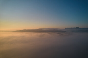 Landscape shot above the fog. Hill panorama of swabian alb on the horizon. Blue sky for copy space. Aerial view. Summer in Germany.