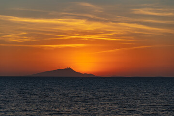 Fototapeta na wymiar Beautiful sunset with sun hiding behind Ischia island over Tyrrhenian Sea
