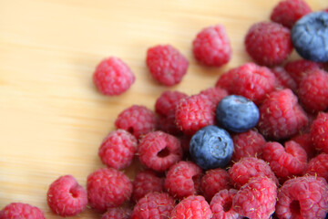 blueberries and raspberries on a wooden background