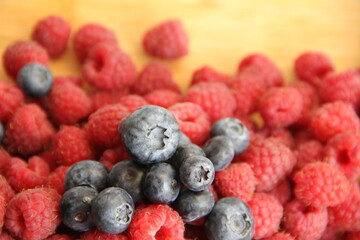 blueberries and raspberries on a wooden background