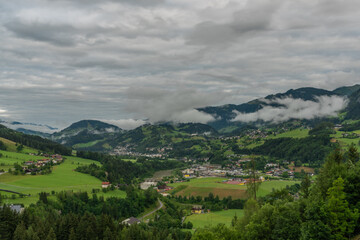 Fototapeta na wymiar Hills and valley near Sankt Johann im Pongau with fog and green meadows