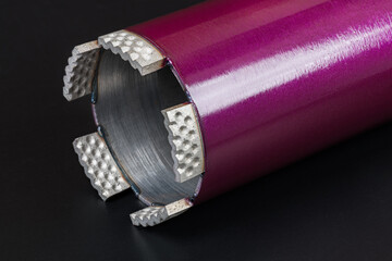 Modern core drill bit in beautiful detail on a black background. Purple water cooled hole saw...