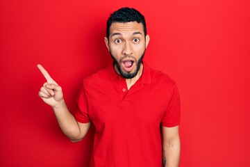 Hispanic man with beard pointing with fingers to the side afraid and shocked with surprise and amazed expression, fear and excited face.