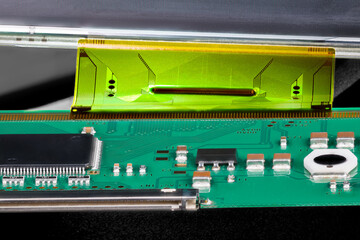 Printed circuit board connected by flexible flat cable to a LCD panel. Closeup of electronic...