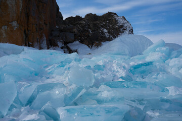 Fototapeta na wymiar rocks with ice overlaps and icicles near the lake