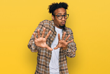 Young african american man with beard wearing casual clothes and glasses moving away hands palms...