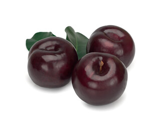 Three plums with leaves on white background