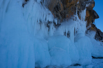 rocks with ice overlaps and icicles near the lake