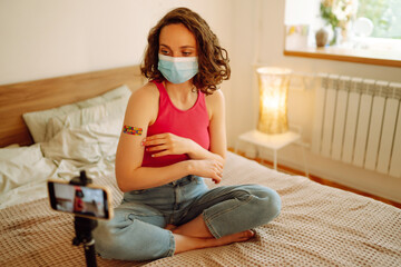 People vaccination concept for immunity health. Woman blogger videotapes her vlog at home and...