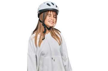Teenager caucasian girl wearing bike helmet winking looking at the camera with sexy expression, cheerful and happy face.