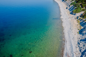 Fototapeta na wymiar Aerial view of coastline with quiet sea and beach. Summer day on transparent sea