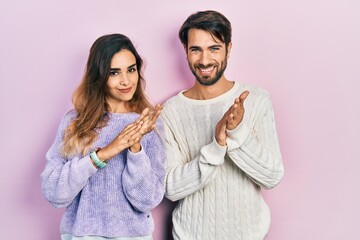 Young hispanic couple wearing casual clothes clapping and applauding happy and joyful, smiling proud hands together