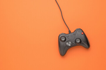 A gaming console on a bright orange background. Flat lay. © kvladimirv