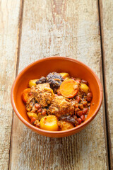 Jewish dish chelnt with meat on a wooden table in a plate.