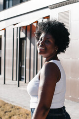 happy African American woman walks down the street in the summer