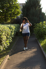 happy African American woman with a phone on the street in the summer