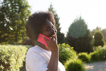 Fototapeta premium happy African American woman with a phone on the street in the summer