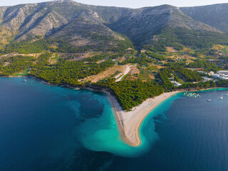 Aerial view of the Zlatni Rat sandy beach, sea and mountains on Brac island, Croatia made with drone