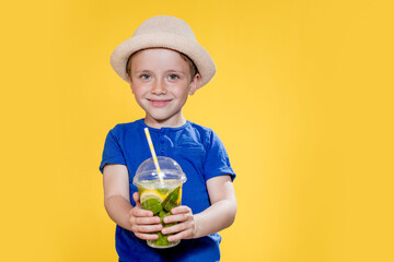 Portrait of a beautiful boy. Happy child. European boy in a hat, summer t-shirt with lemonade. Summer, vacation, vacation, sun, heat, sea, beach. Face for advertising.