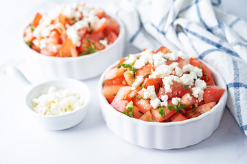 Fototapeta na wymiar Feta cheese tomato salad in a white bowl