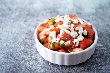 Feta cheese tomato salad in a white bowl