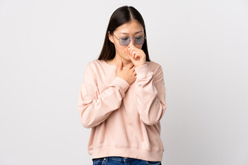 Young Chinese girl over isolated white background coughing a lot