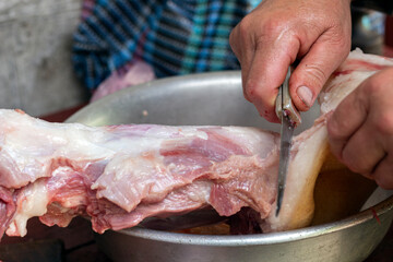 Portioning of pig carcasses. A man has a butcher knife