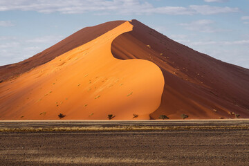 Towering sand dunes near Sossusvlei at sunrise in the Namib desert, Namib-Naukluft National Park,...
