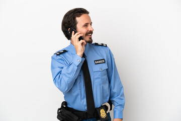 Fototapeta premium Young police man over isolated background white keeping a conversation with the mobile phone with someone