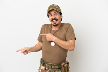 Soldier man isolated on white background surprised and pointing side