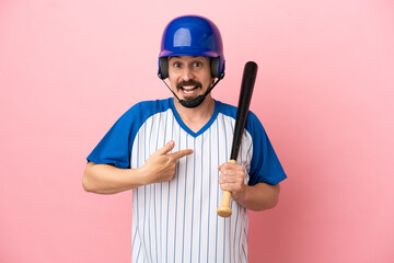 Young caucasian man playing baseball isolated on pink background with surprise facial expression