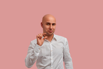Few inches, centimeter. Funny bald man with bristle in white shirt, showing a little bit gesture,...