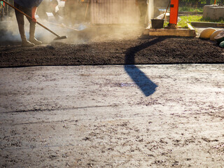 Laying new asphalt. The process of leveling the asphalt manually using a special rake.