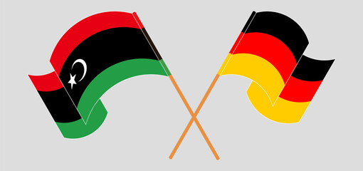 Crossed and waving flags of Libya and Germany