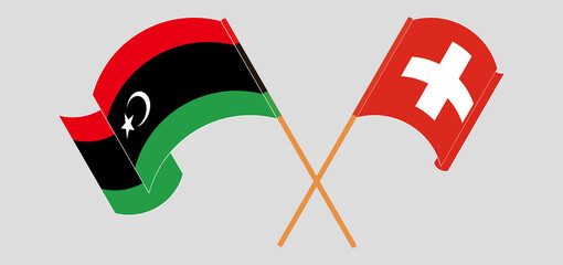 Crossed and waving flags of Libya and Switzerland