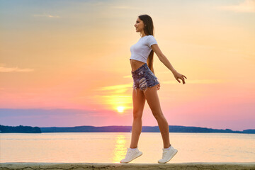 Happy young woman enjoys freedom in sunset time