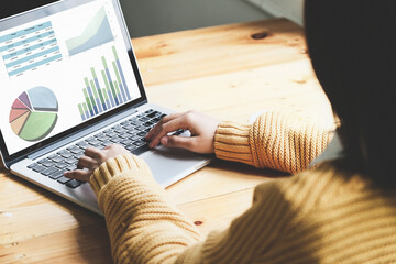 A female employee using computer to check the company's investment budget.