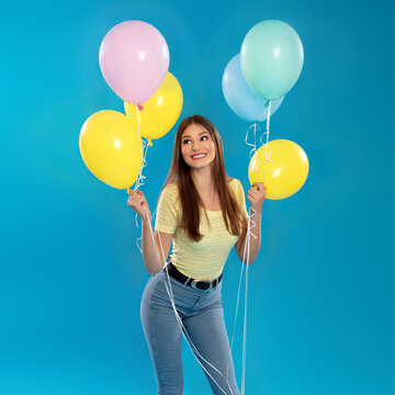 Portrait of beautiful young girl holding balloons