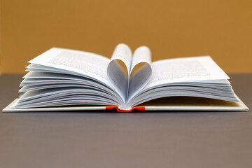 Open book with pages forming heart shape. Heart made with book pages.